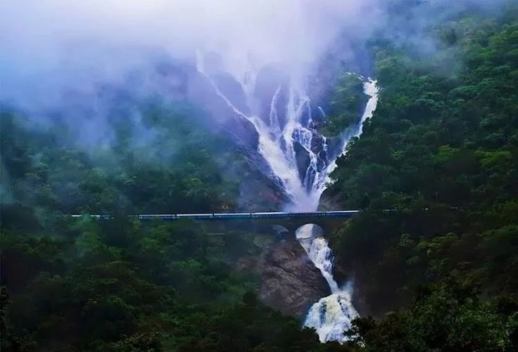 Dudhsagar Falls in Goa during the monsoon season with heavy water flow and misty surroundings