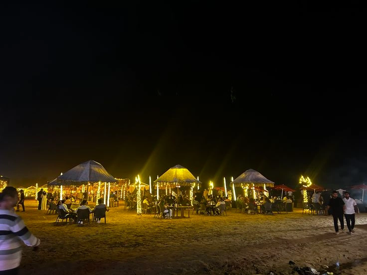 Nighttime beach shacks and cafés in Goa during the peak winter season with active crowds and lighting